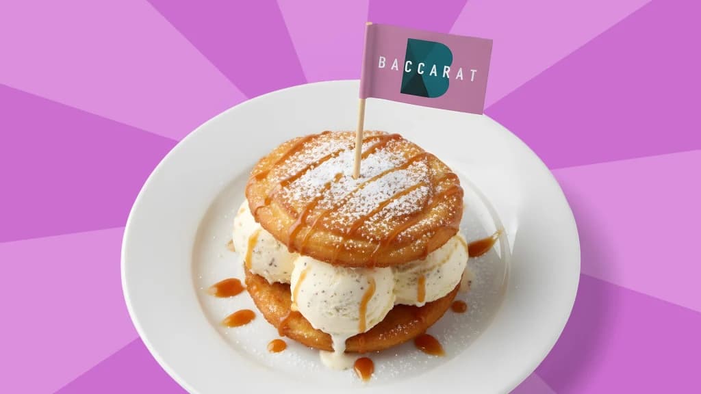 Three ice-cream scoops are inside a pastry, with a purple flag that says “baccarat” poked in the middle. 