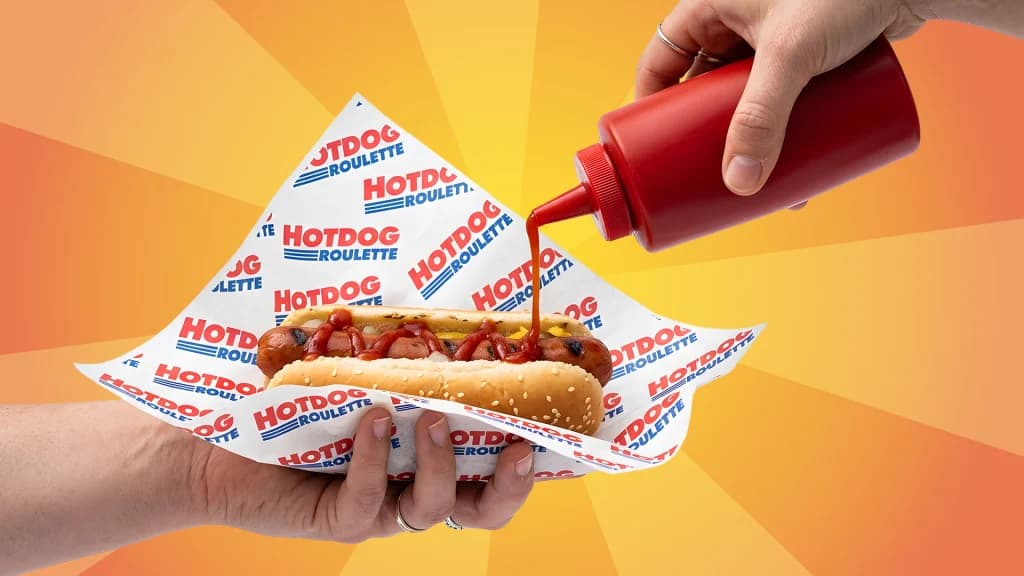 Someone squeezes ketchup onto a “Roulette Hotdog,” with the paper shown in the style of Costco. 