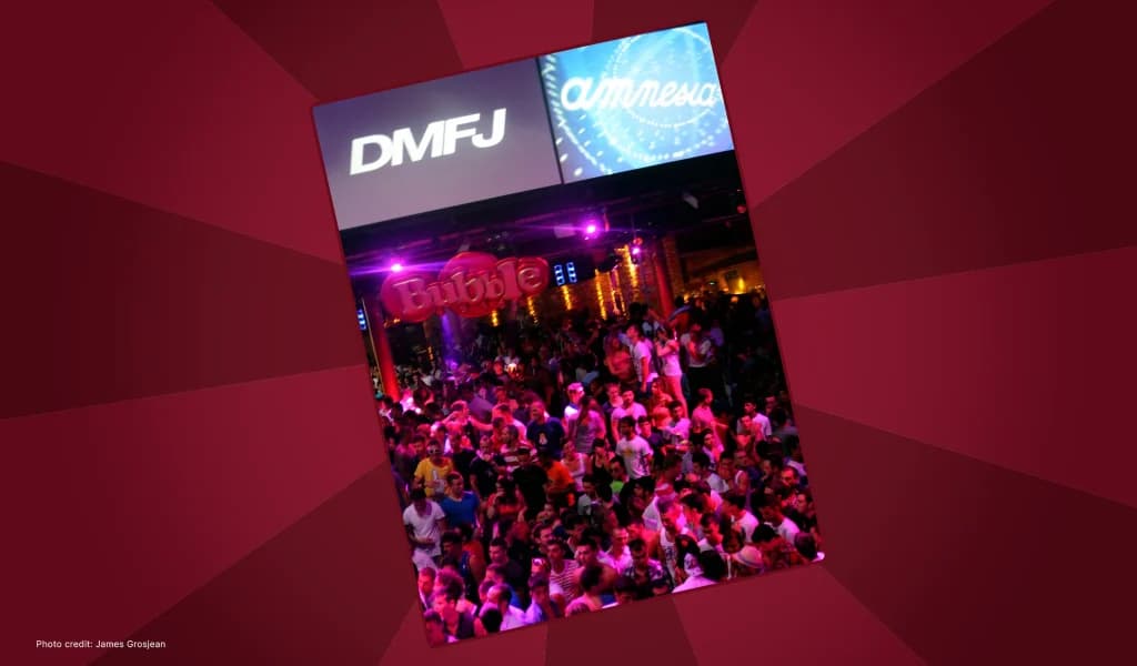Packed nightclub crowd at an Ibiza event with DMFJ branding on the screens above.