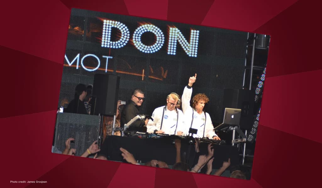 Don Johnson standing behind DJs on stage with his name lit up on a large LED screen.