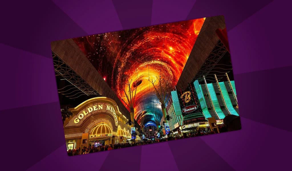 Fremont Street Experience in Las Vegas at night with the Golden Nugget and Binion's casinos lit up below a vivid LED canopy display