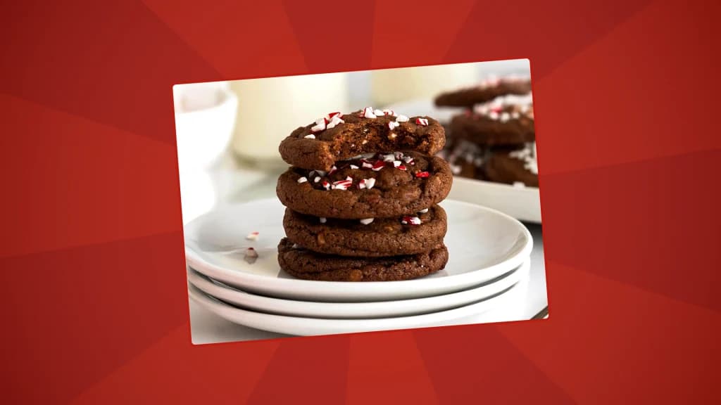 chhocolate cookies are stacked on a plate with peppermint sprinkles