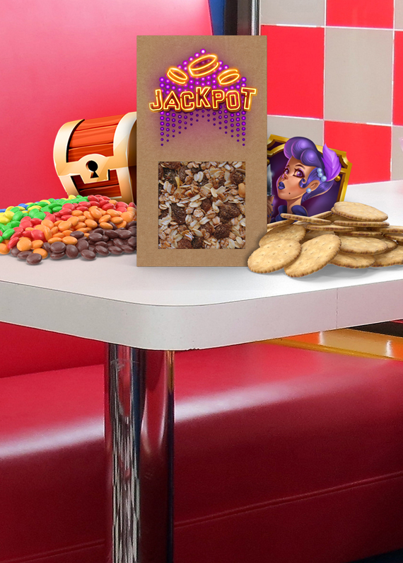 A cardboard packet of mixed nuts, with the word “jackpot” on top, sits on a white cafe countertop, surrounded by cookies and a pile of multicolored M&Ms. To the left is a 3D-animated treasure chest in brown and gold, while on the right is an animated cartoon character of a female with long purple hair, both icons from Cafe Casino slot games.
