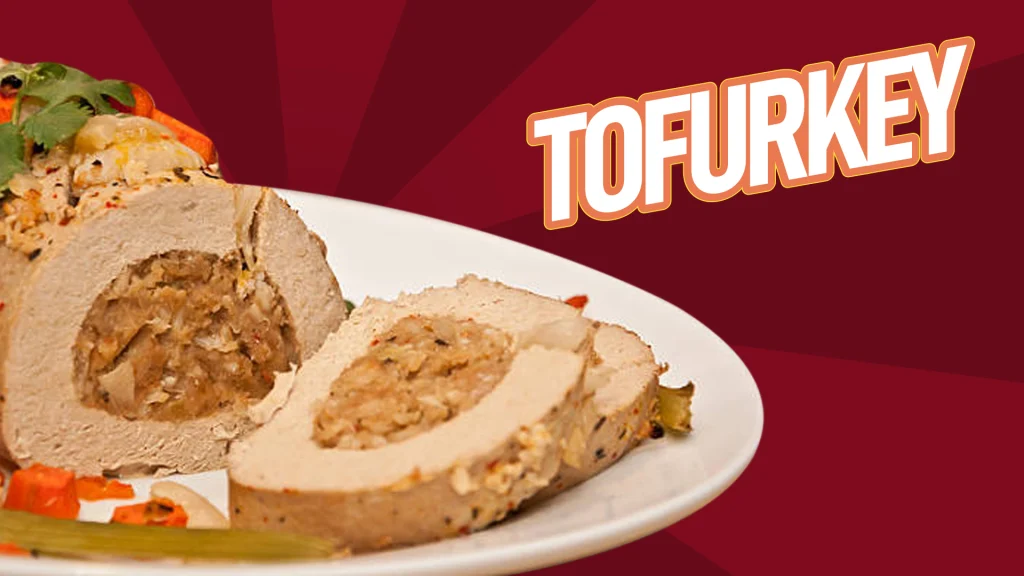 Sliced, stuffed turkey roll on a platter against a purple background with the word ‘Tofurkey’ overlaid.