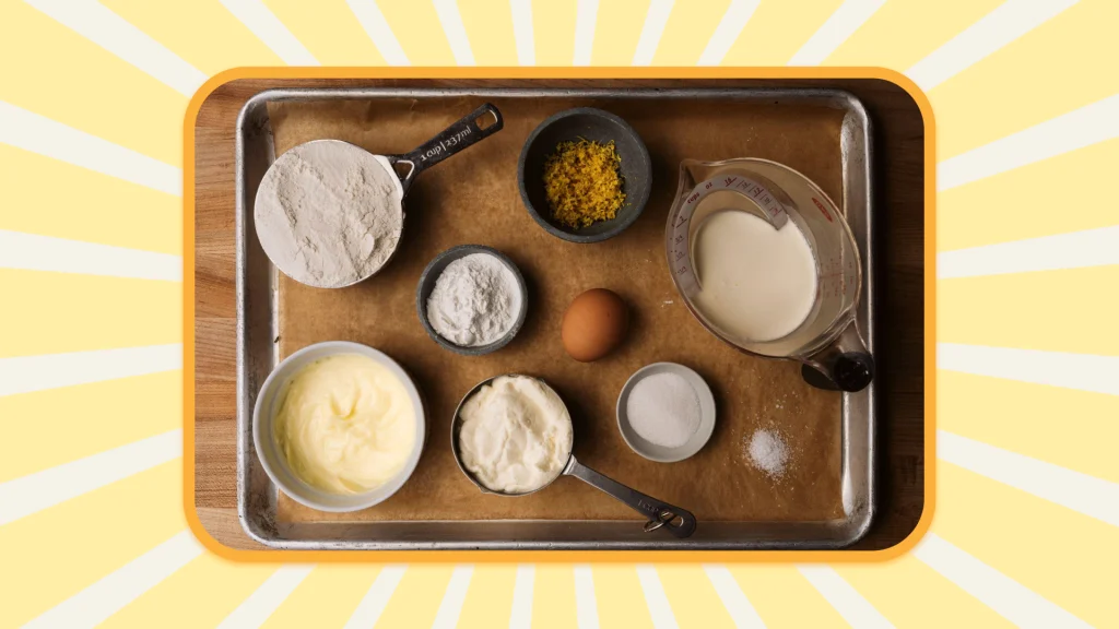 Lemon ricotta pancake recipe ingredients on a baking tray, in small dishes and measuring cups.