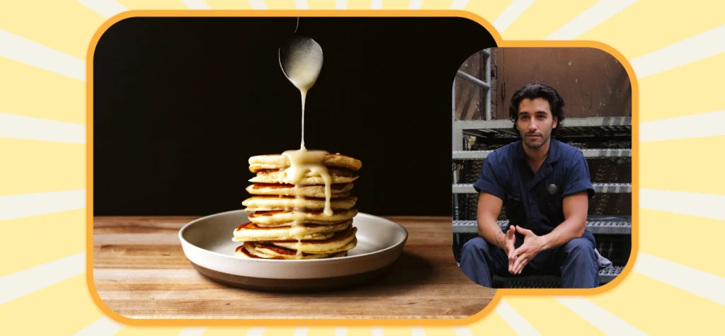 A tall stack of lemon ricotta pancakes stands in a brunch bowl, with a spoon drizzling lemon curd sauce from above. Matt Broussard is on the right; all on a striped yellow background.