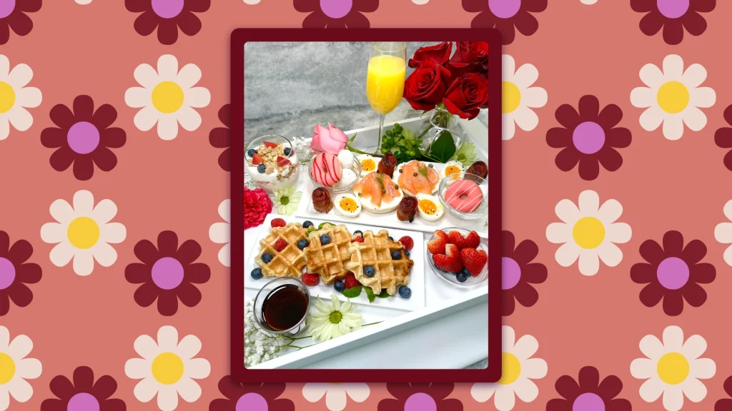 Mother's Day breakfast platter of food with beautiful flowers framed against a floral background.