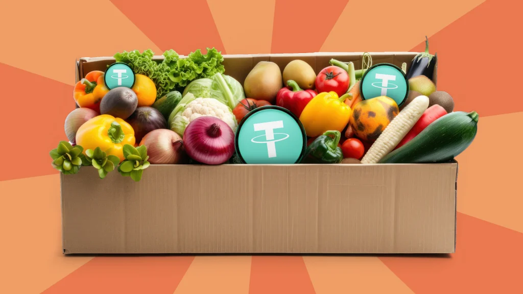 A box full of fresh vegetables has the USDT logo in the center and it’s in the middle of a peach background.