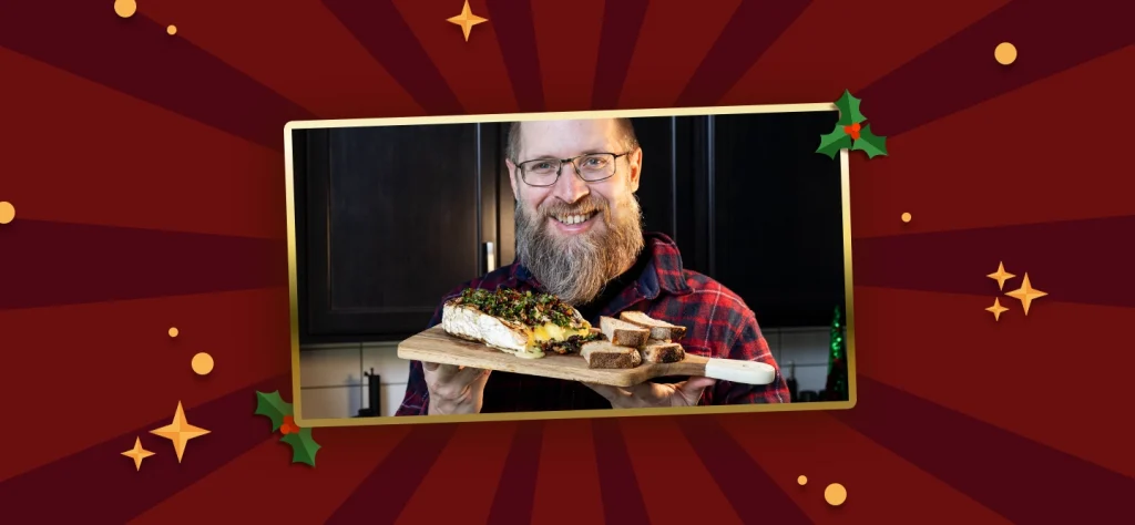 on a red background is a photo of Brad Prose holding a wooden board of grilled brie and bread