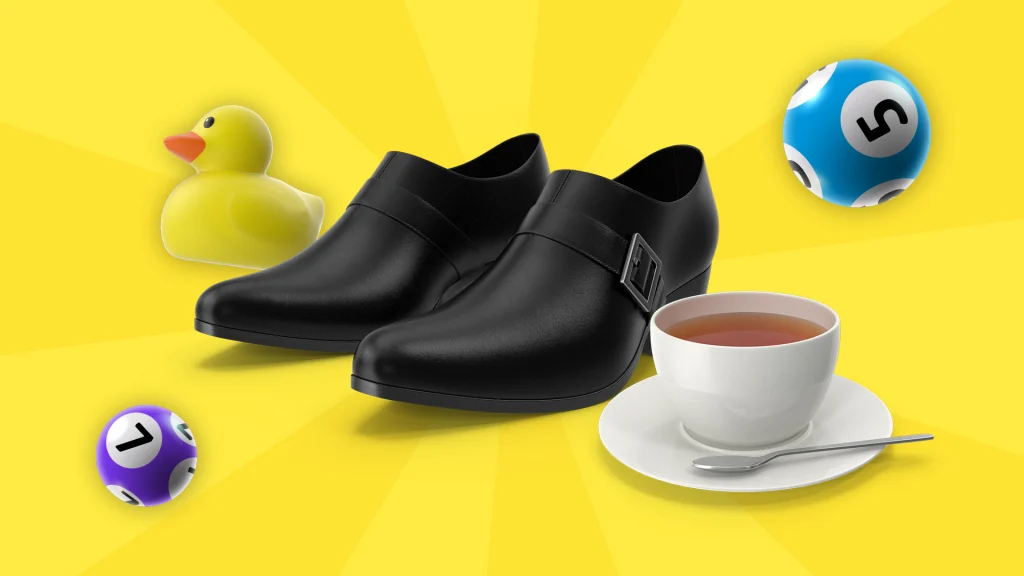 A pair of black shoes is in the middle of a yellow image. A yellow rubber duck, two bingo balls, and a cup of tea surround them. 