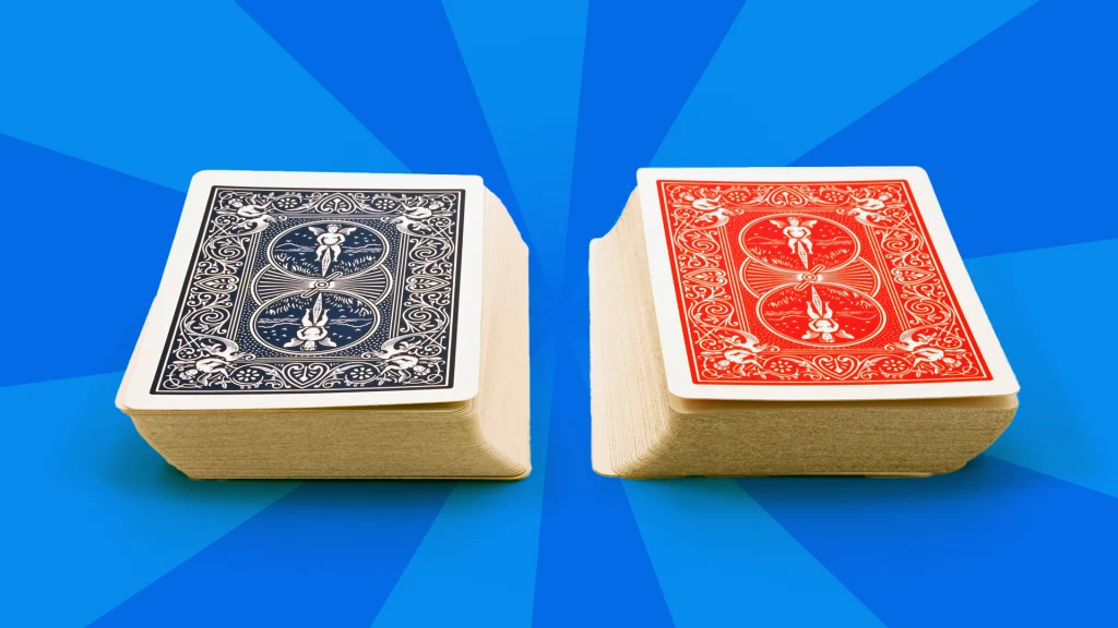 There’s a blue and a red deck of cards on a blue background. 