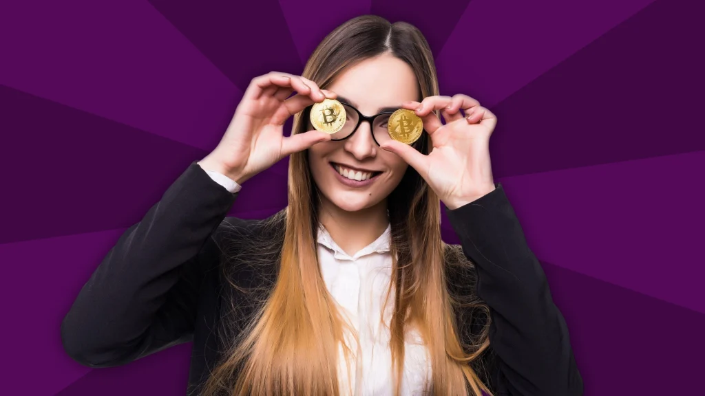 A woman with long blonde hair holds up two Bitcoins to her eyes, and she’s shown over a purple background. 