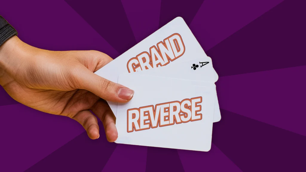 Hand holding playing cards with the words 'GRAND' and 'REVERSE', illustrating Martingale betting variations in baccarat.