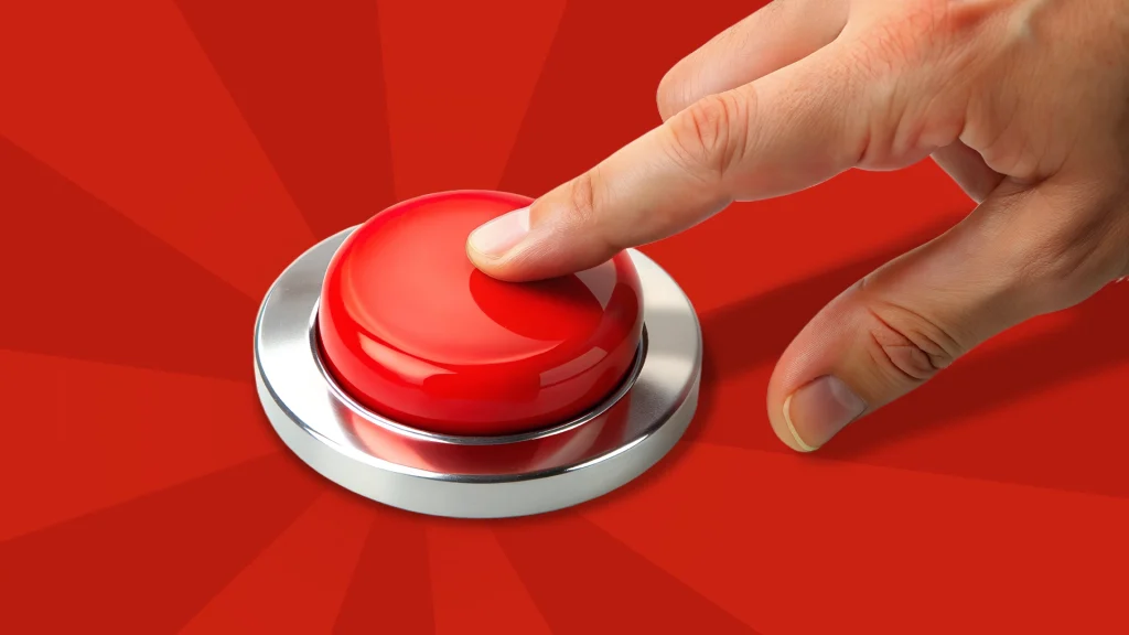 A finger is about to push a red button on a red background