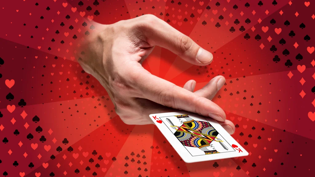 A hand emerges from a red background dotted with playing card symbols, showing a King of Hearts