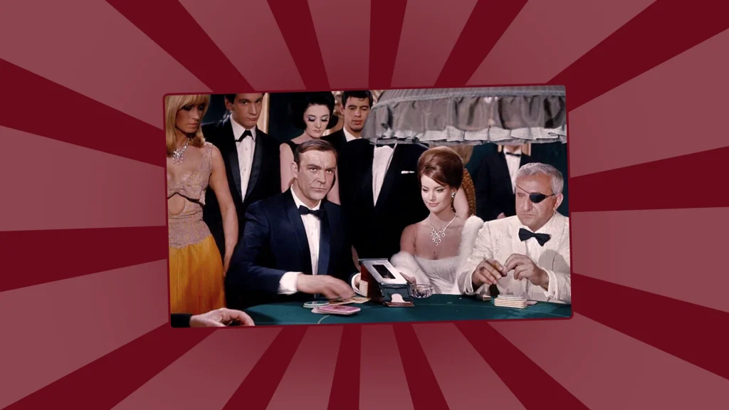 James Bond and other players in formal attire seated at a casino table during a baccarat game.