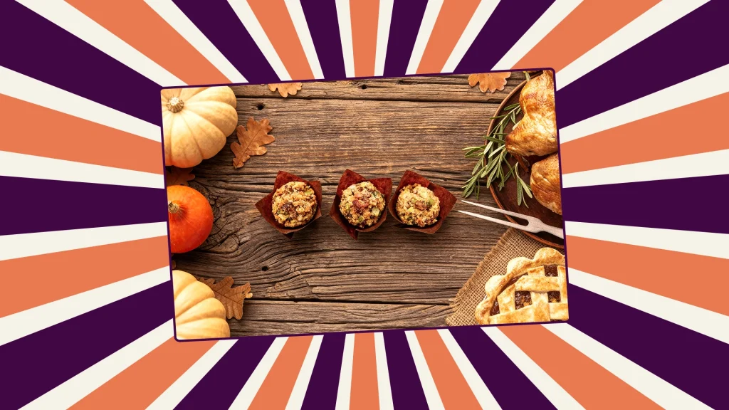 3 mini stuffing bites on a wooden table surrounded by pumpkins and roast turkey